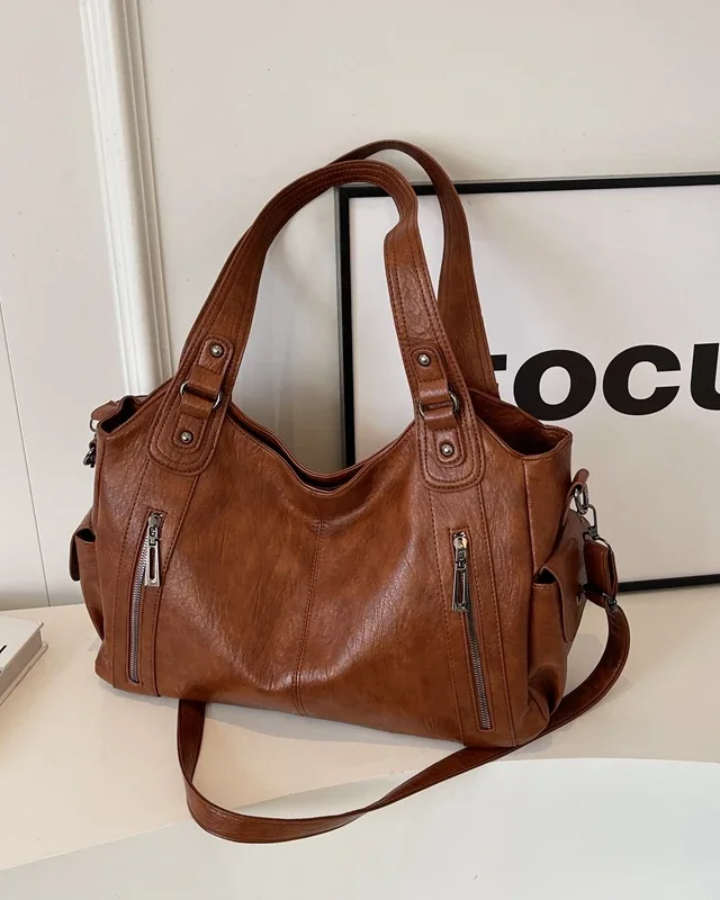 Elegant black Lumina Wear shoulder handbag with functional design, featuring amber accents and a sleek, stylish look.