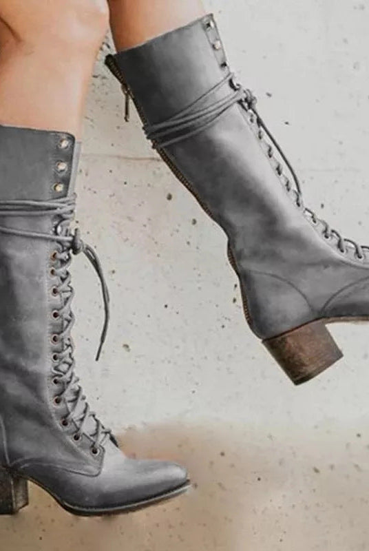 Black lace-up knee-high boots with a block heel from Lumina Wear, featuring an edgy design and sleek silhouette.