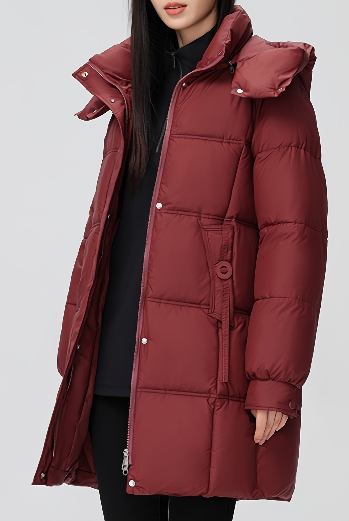 Black Amelia Lumina Wear hooded longline puffer coat with belt, stylish and warm, shown on a model.