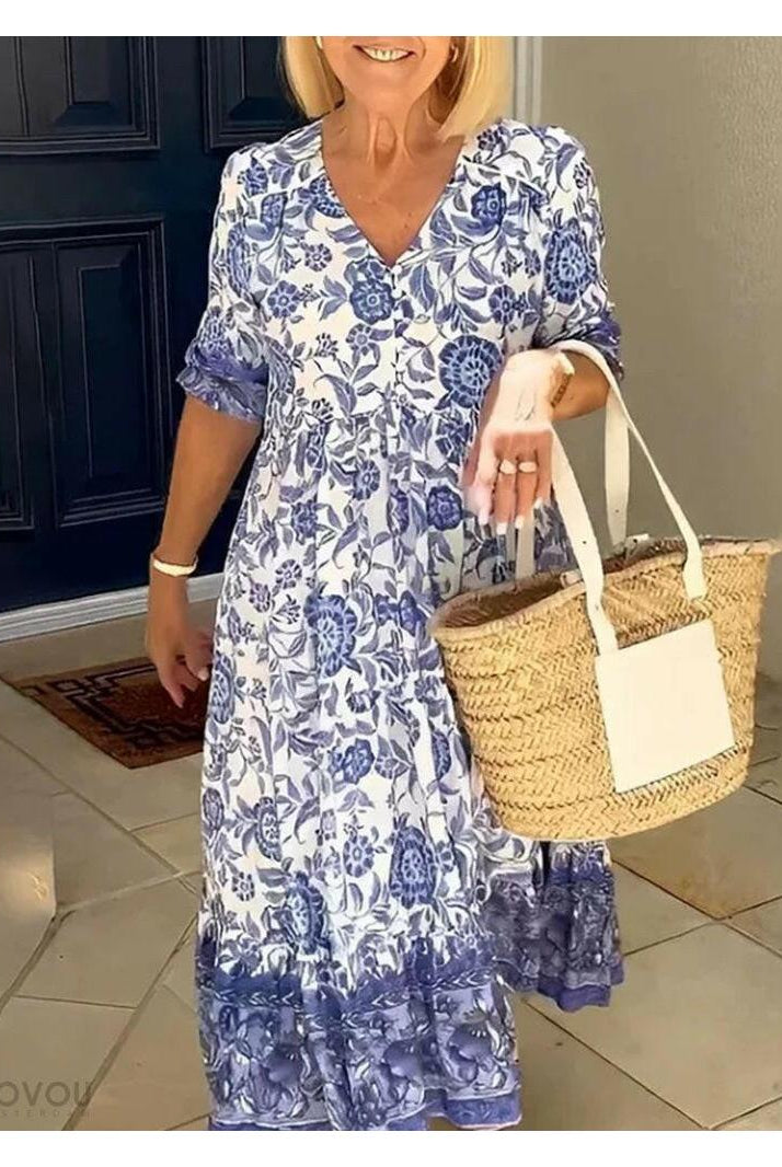 Blue Lumina Wear ARIA floral dress with V-neck, elegant design, showcased on a hanger with a subtle floral pattern.