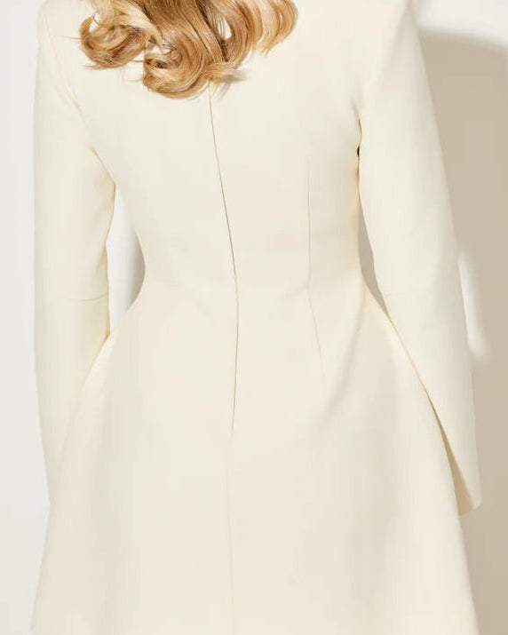 White Aurora coat dress with a statement bow collar by Lumina Wear, shown on a model in Vancouver.
