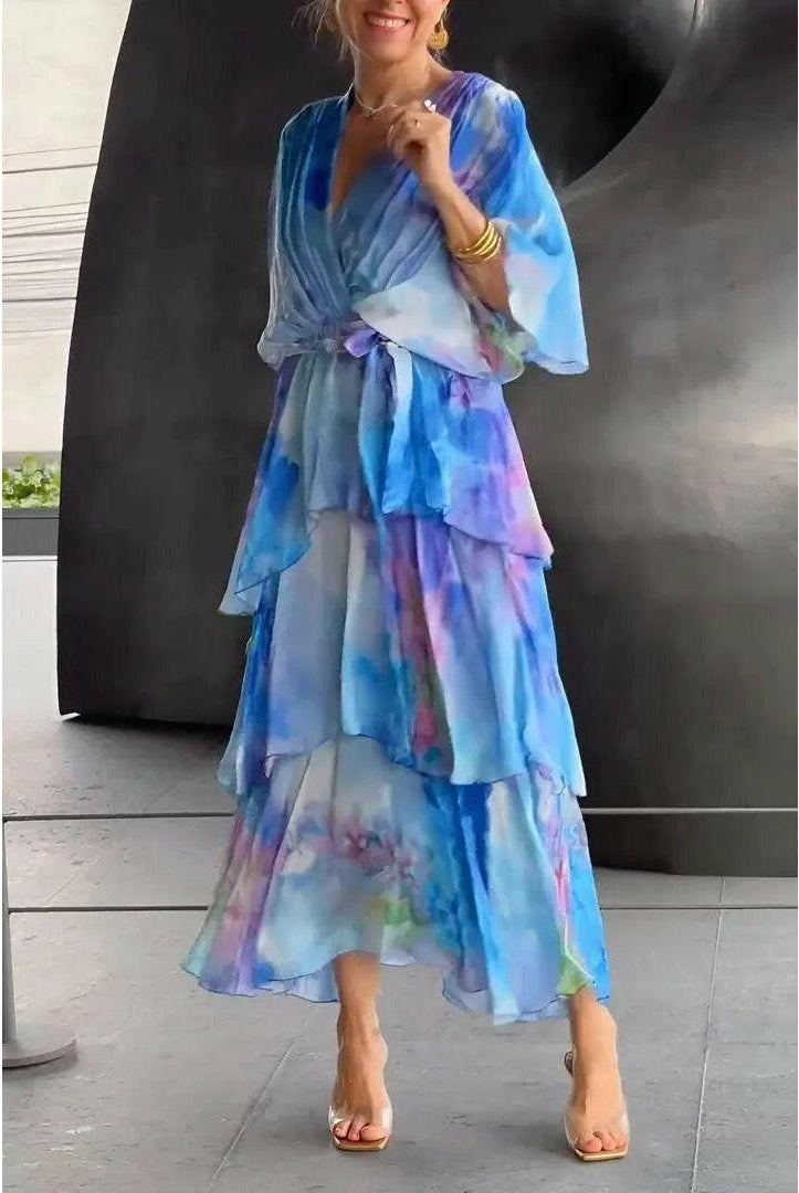Light blue Avalance maxi dress by Lumina Wear featuring elegant multi-color patterns and flowing fabric.