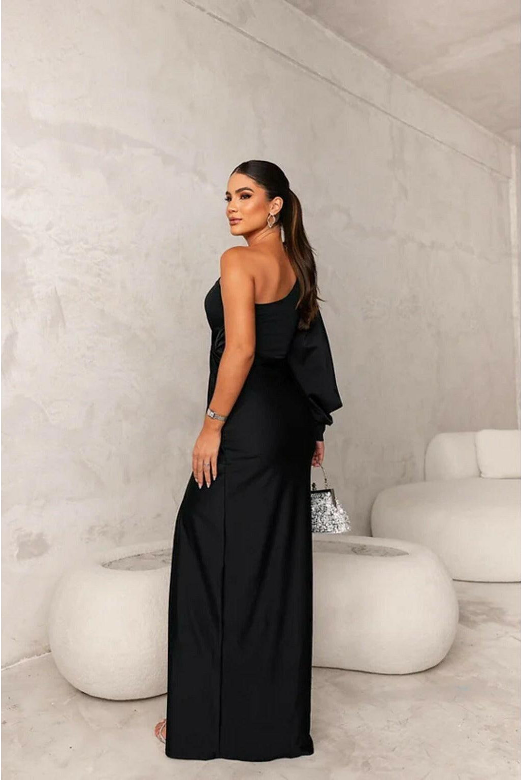 Olive green Becca Lumina Wear elegant satin maxi dress, worn by a wedding guest, showcasing flowing fabric and sophisticated style.