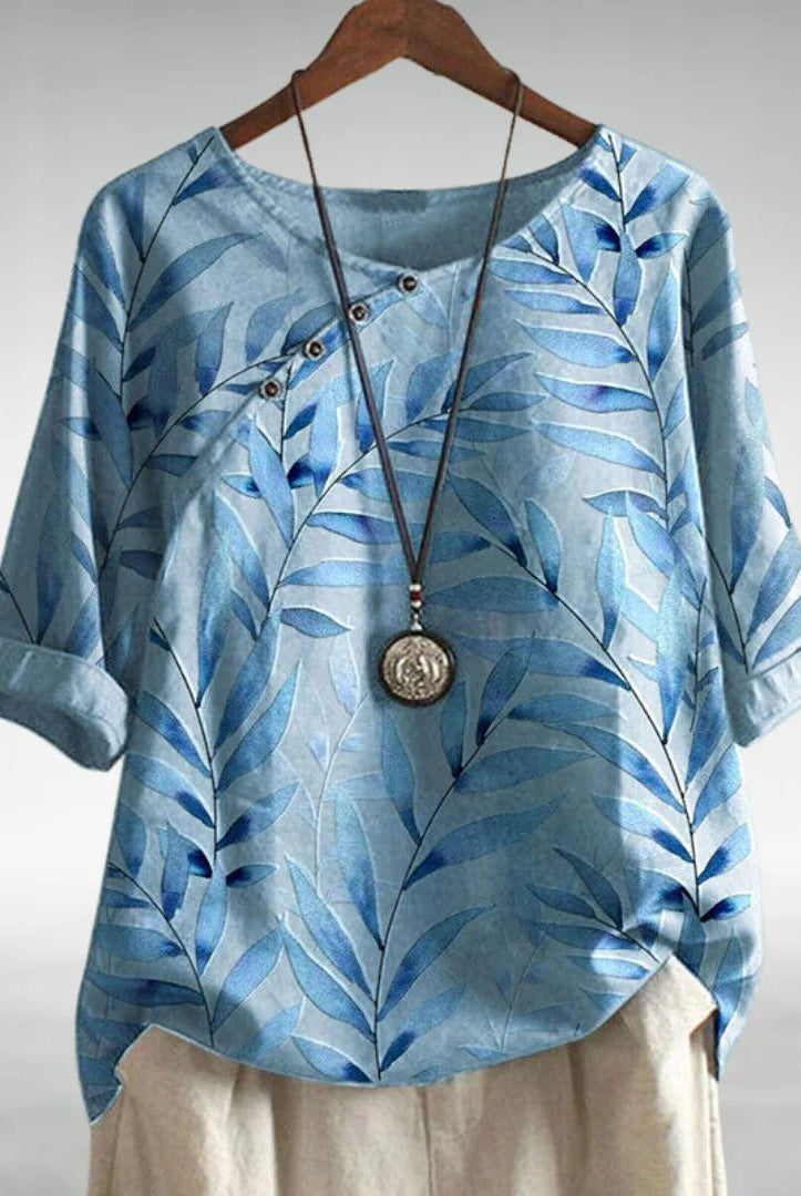 Charlotte Breezy Leaf Print Blouse by Lumina Wear, featuring a button-up design and vibrant leaf pattern in blue.