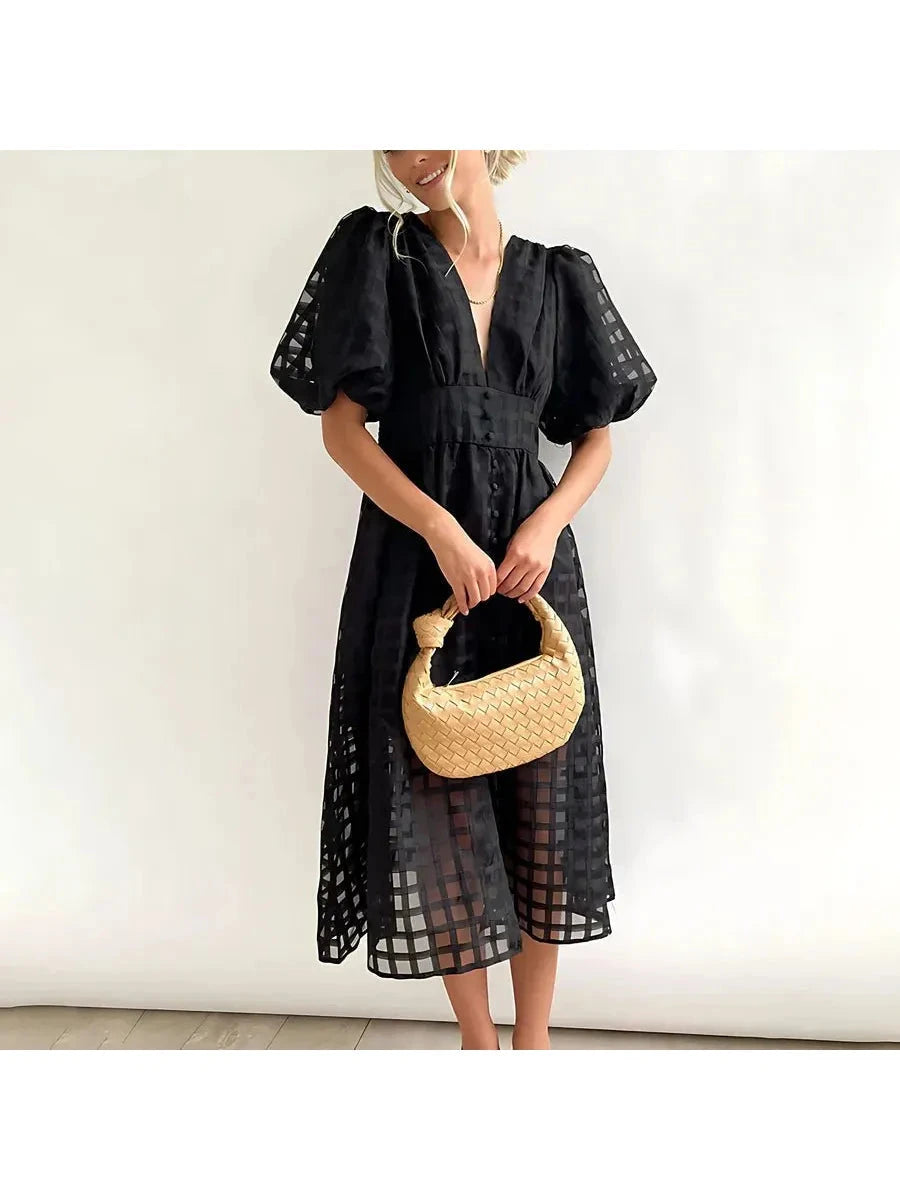 Pink Cindy midi dress by Lumina Vancouver featuring classic patterns and puff sleeves, displayed on a hanger.