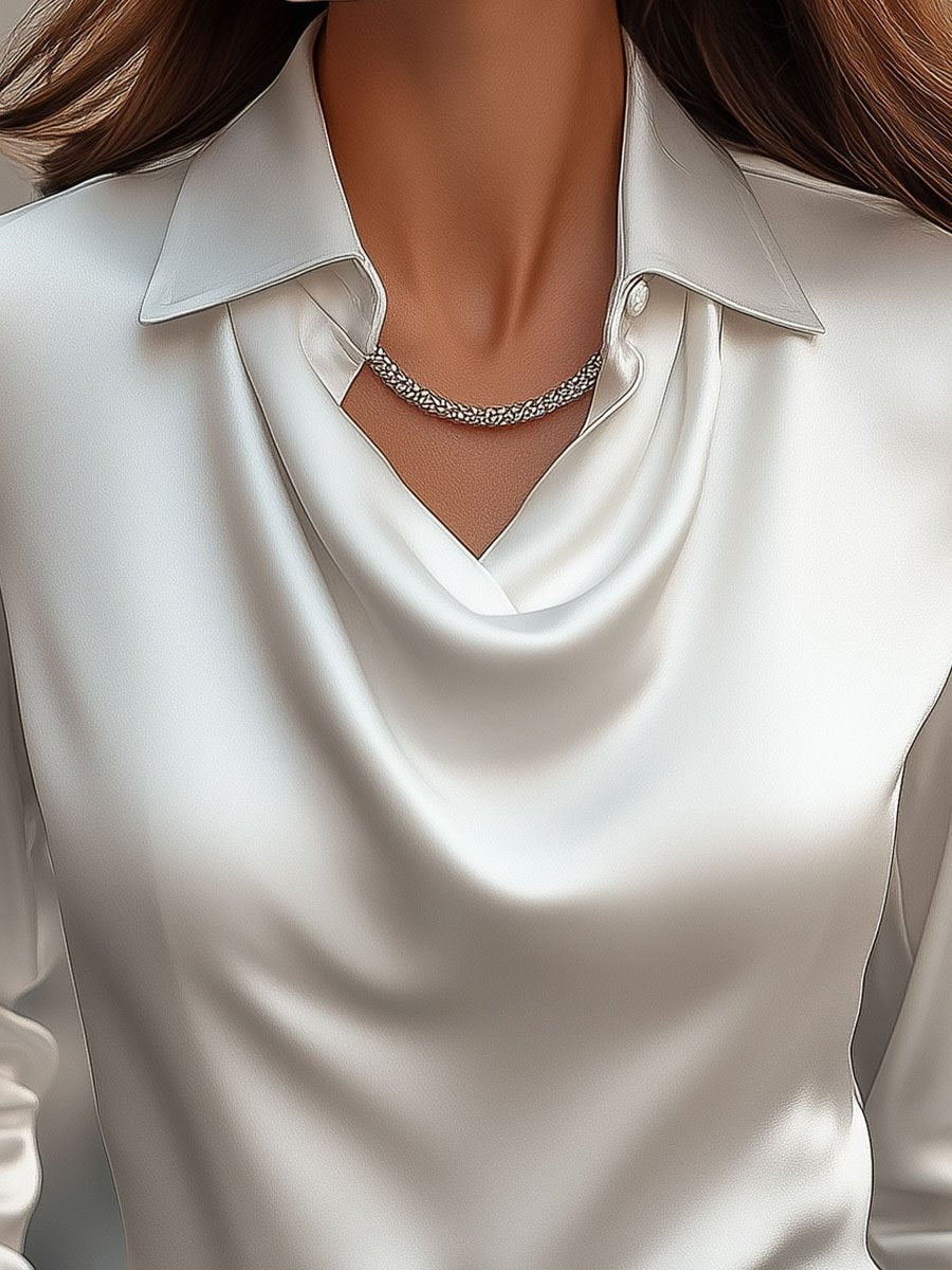 White satin draped blouse named Delphine by Lumina Vancouver, shown in XS size with elegant draping and long sleeves.