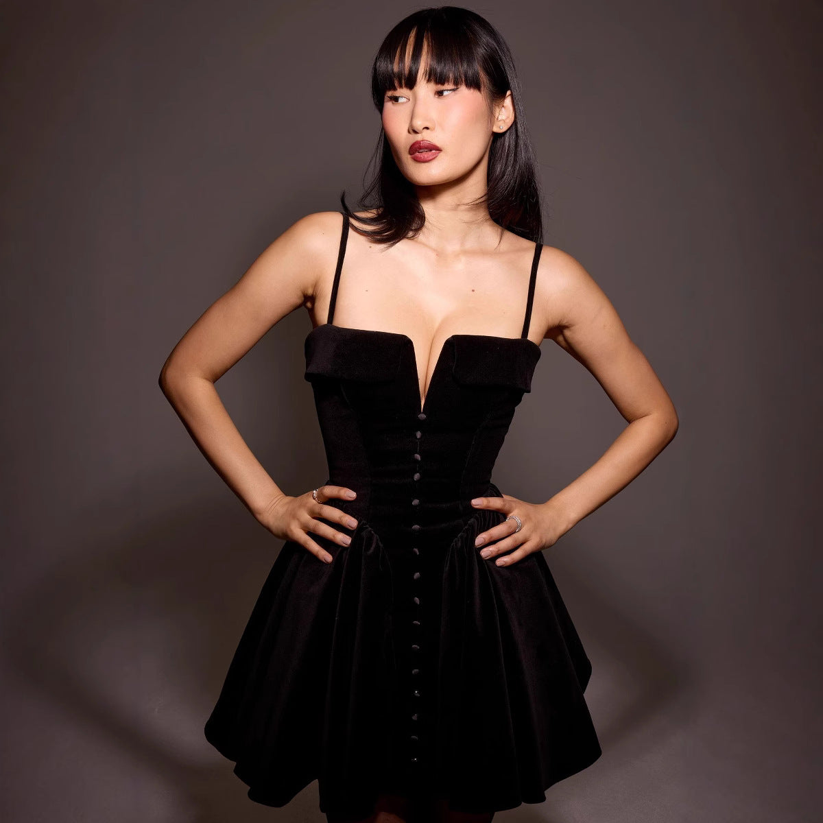 Black velvet Elara A-line mini dress by Lumina Vancouver, showing a close-up of the fitted bodice and flowing skirt.