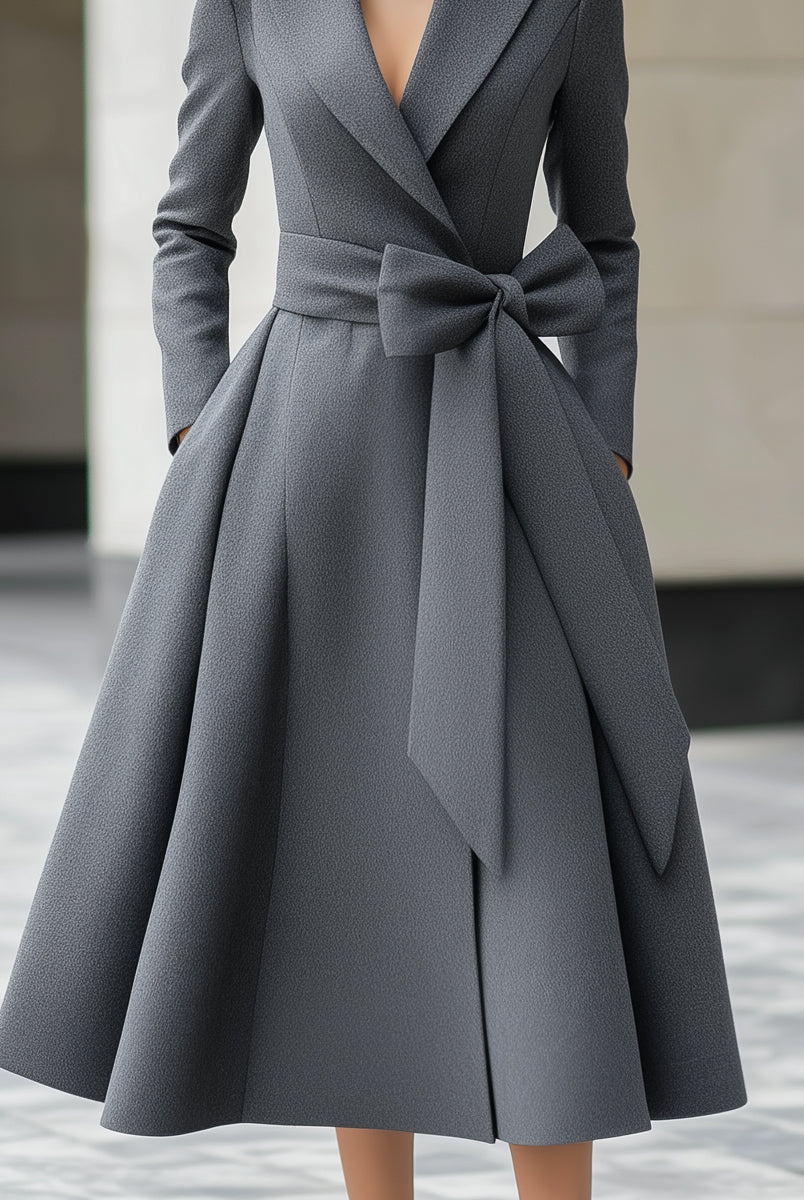 Grey Yvette A-line coat dress by Lumina Vancouver with bow belt detail, shown on a model in a stylish outdoor setting.