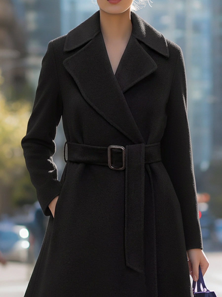 Black Lumina Vancouver Edith wool-blend midi coat with belted lapel collar, shown on a model in a stylish outdoor setting.
