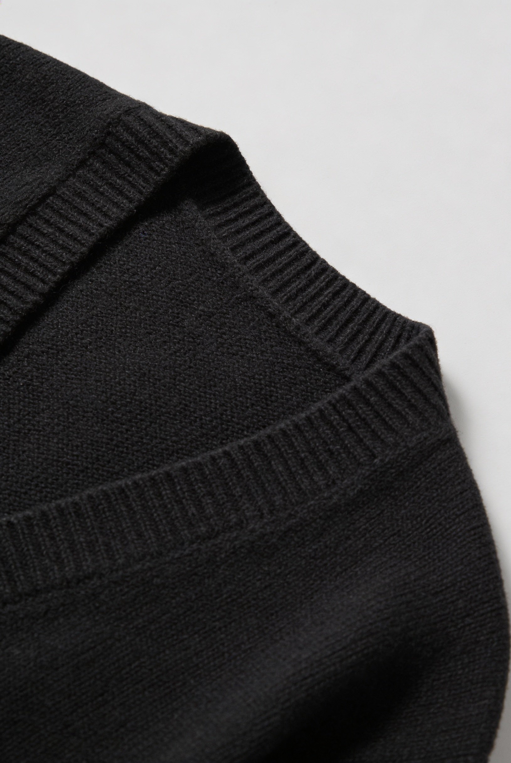Black knit cardigan with ribbed details from Lumina Wear, featuring a cozy fit and classic style for casual wear.