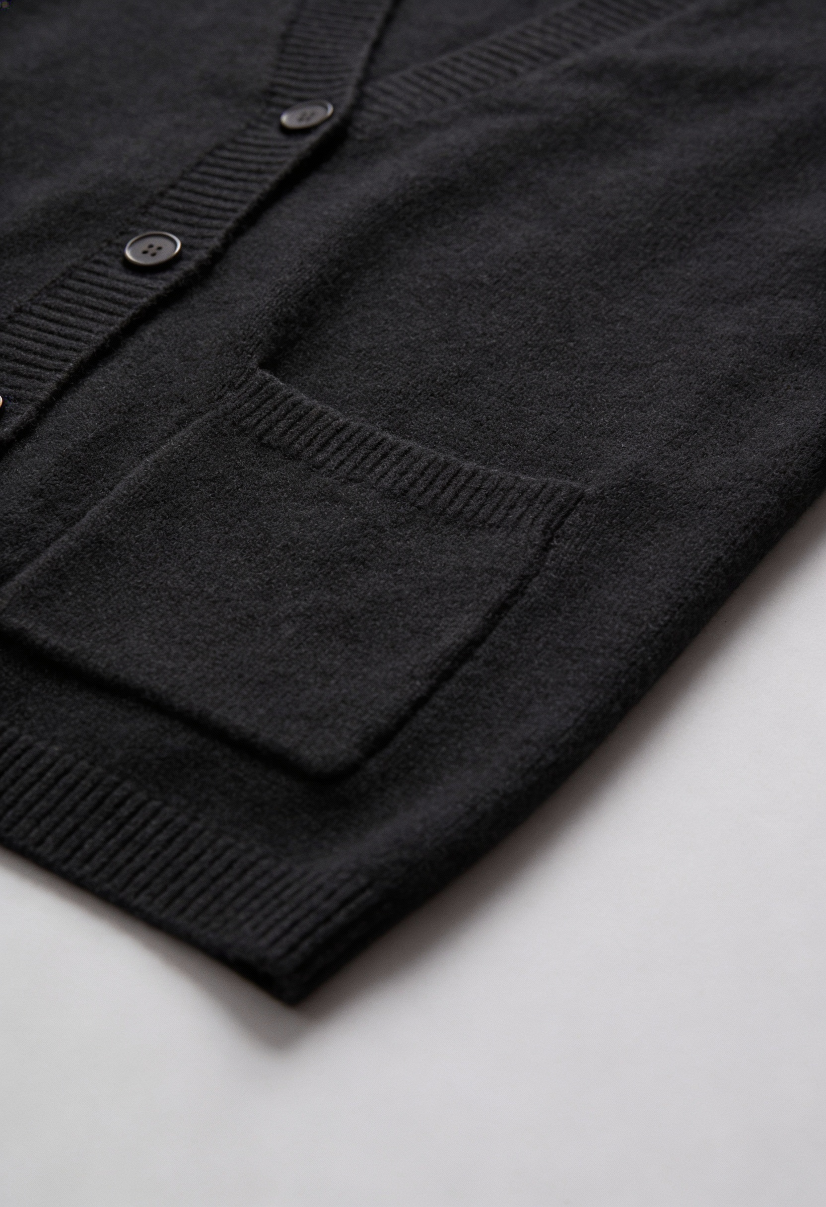Black knit cardigan with ribbed details from Lumina Wear, featuring a cozy, fitted design perfect for casual wear.
