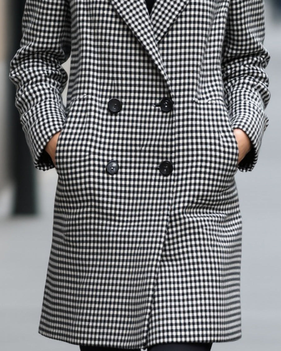 Black Enid double-breasted checked wool coat by Lumina Wear, shown on a model, showcasing classic pattern and tailored fit.