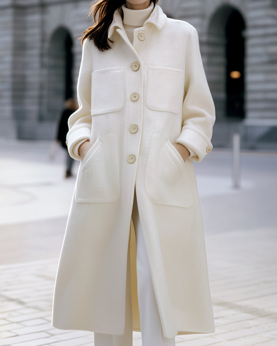 White oversized pocket coat by Lumina Wear, shown on a model, featuring a relaxed fit and stylish design.