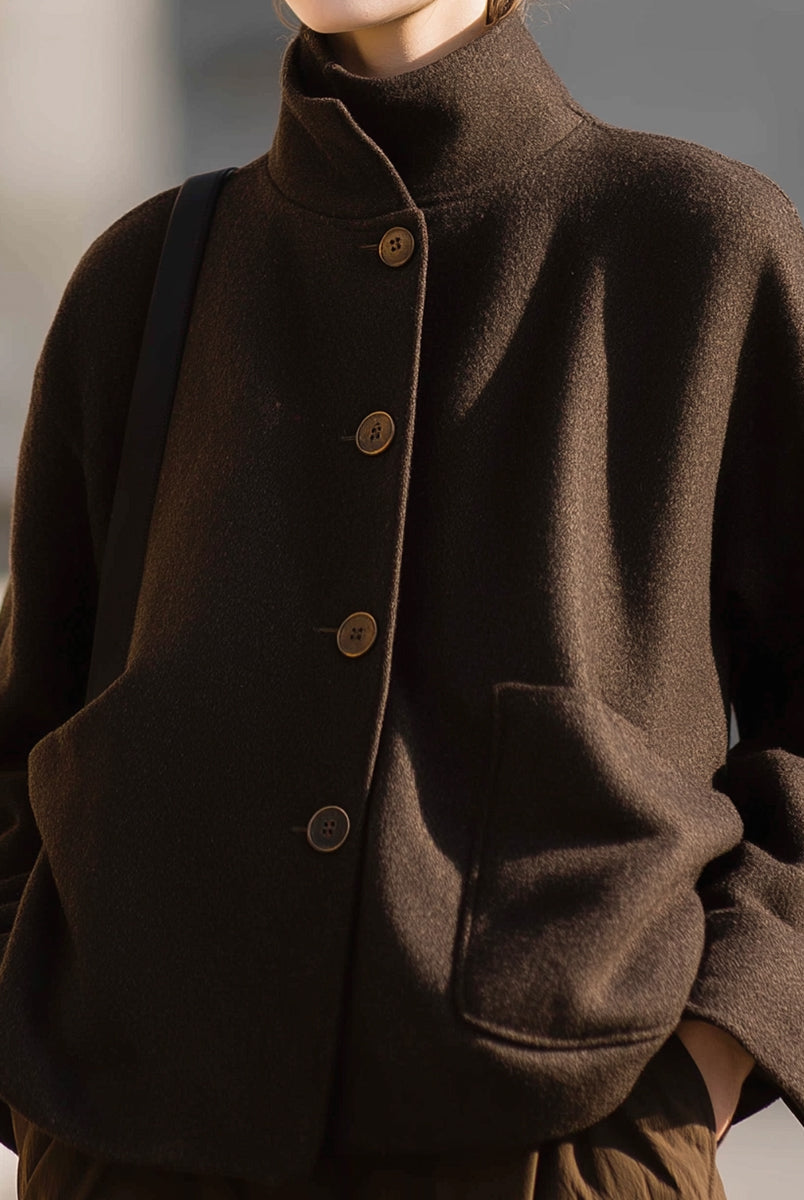 Chocolate stand-collar jacket by Lumina Vancouver featuring a sleek design, worn by Elena in a close-up shot.