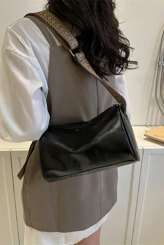 Lumina Wear Florence minimalist black crossbody bag with patterned strap, measuring 9.45in long and 5.91in high.