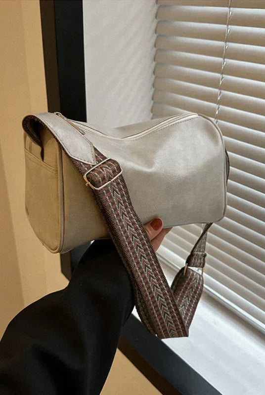 Lumina Florence minimalist black crossbody handbag with patterned strap, featuring sleek design and adjustable strap length.