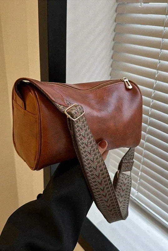 Black Lumina Wear Florence minimalist crossbody bag with patterned strap, compact size and adjustable strap for everyday use.