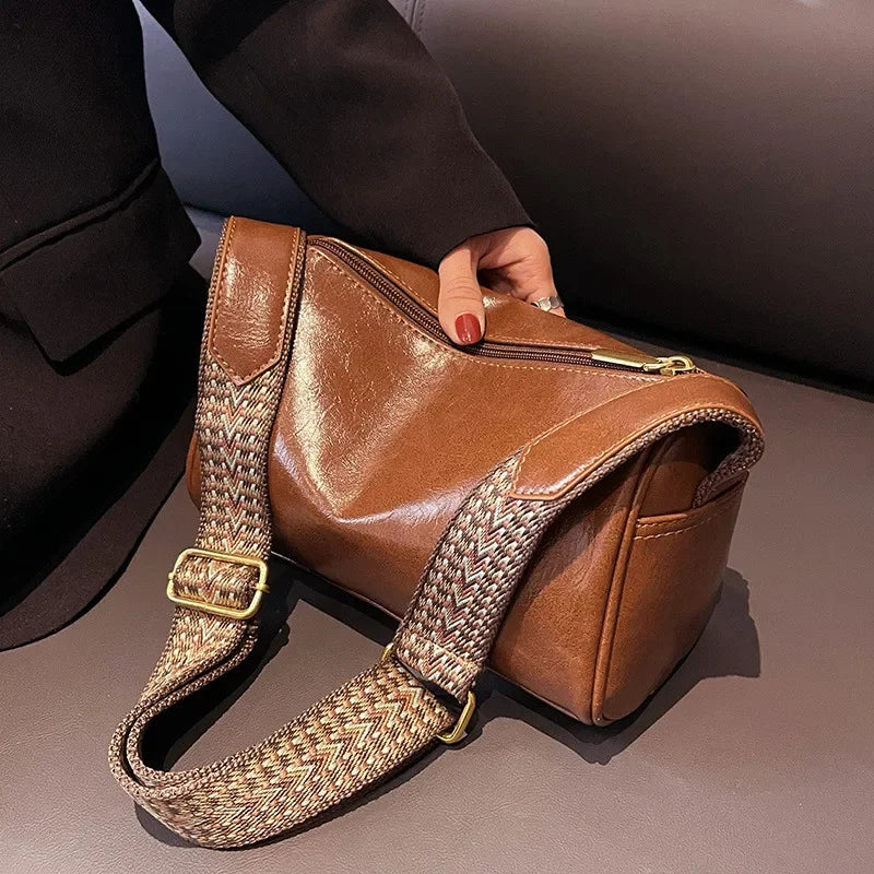 Lumina Wear Florence minimalist black crossbody handbag with patterned strap, featuring adjustable length and sleek design.