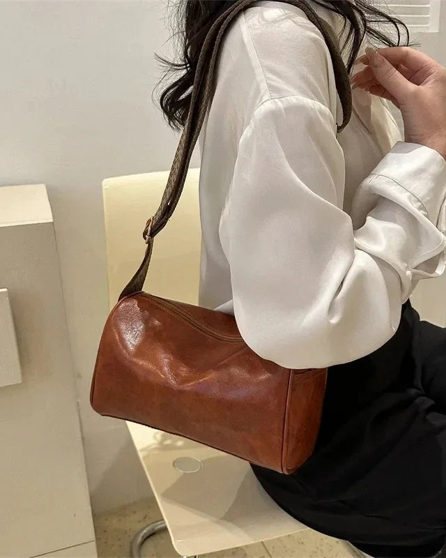 Lumina Wear Florence minimalist black crossbody handbag with patterned strap, featuring adjustable strap length and sleek design.