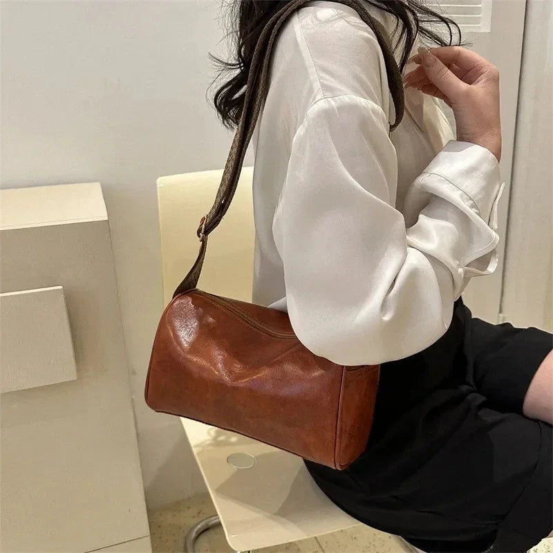 Lumina Wear Florence minimalist black crossbody handbag with patterned strap, featuring adjustable length and sleek design.