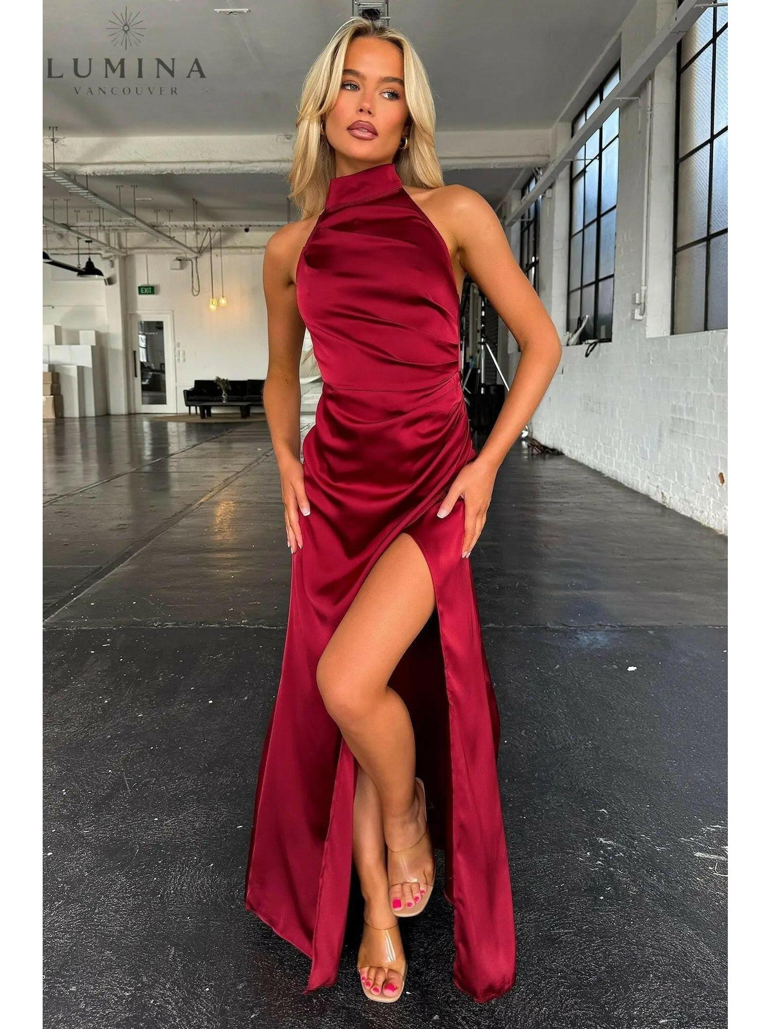 Burgundy Florencia halterneck sleeveless slit maxi dress by Lumina Wear, perfect for wedding guests, shown on a model.