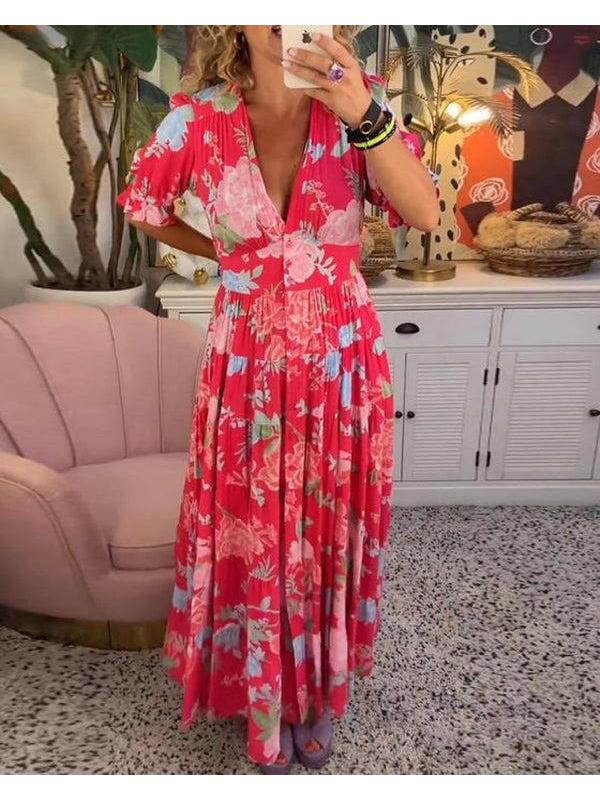Red Floriana™ vibrant floral dress by Lumina Vancouver, shown hanging with bold floral pattern and flowing fabric.