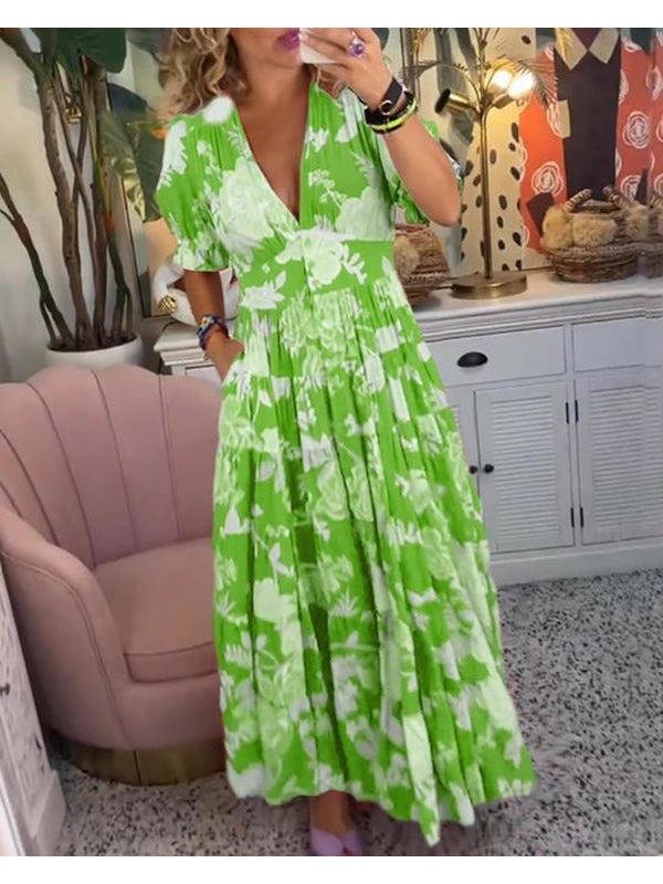 Red Floriana floral dress by Lumina Vancouver, vibrant and stylish, displayed on a hanger with a colorful floral pattern.