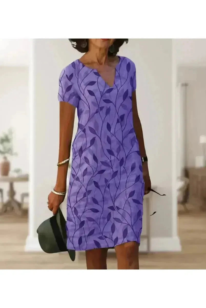 Green Galina casual elegant floral print dress by Lumina Vancouver, shown on a model with a fitted waist and flowing skirt.