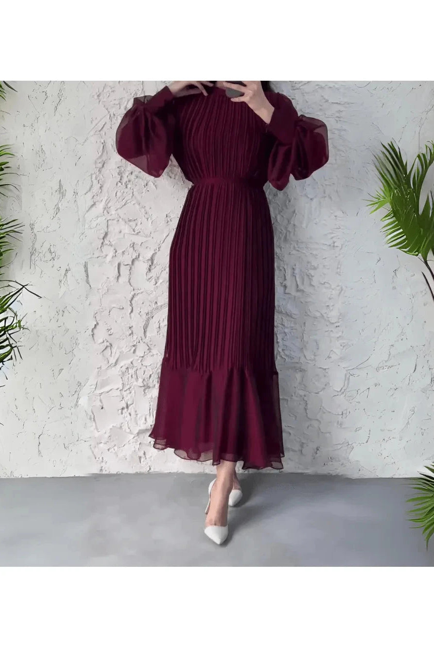 Blue Hannah pleated elegant dress by Lumina Wear, shown on a model with flowing fabric and a sophisticated design.