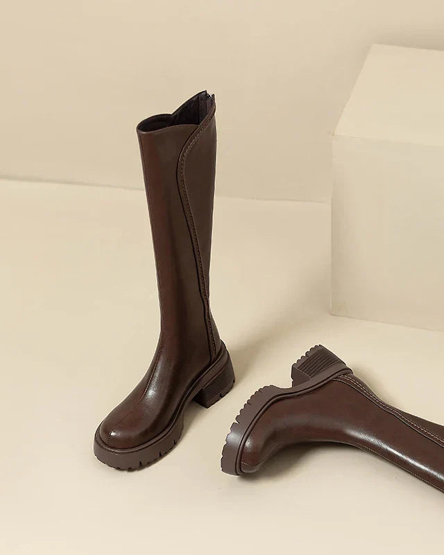 Elegant black knee-high boots by Lumina Wear featuring orthopedic support and brown fur trim, designed for comfort and style.