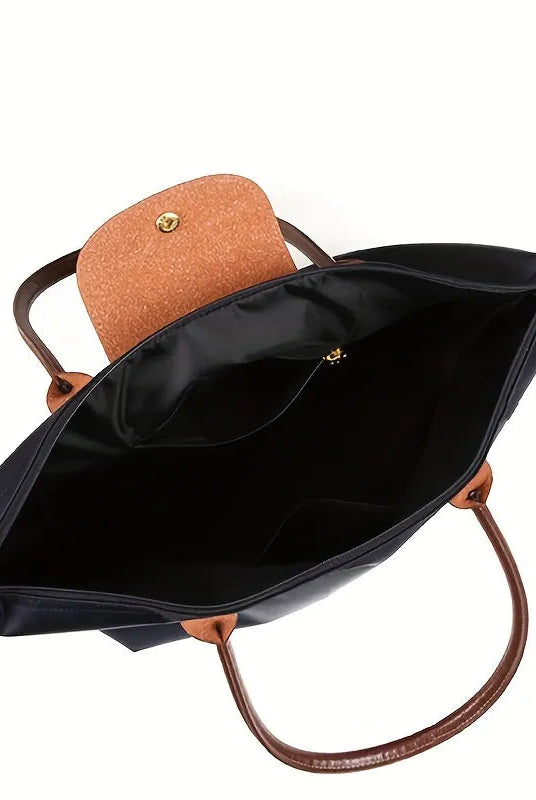 Black faux leather handbag by Lumina Wear, spacious design with chic style, featuring sturdy handles and elegant details.