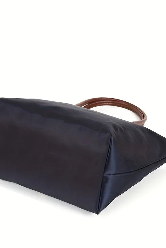 Isabella Lumina black faux leather handbag with spacious design, stylish hand-held bag for women, on a plain background.