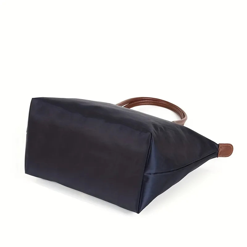 Isabella Lumina black faux leather handbag with spacious design, stylish hand-held bag for women, on a plain background.