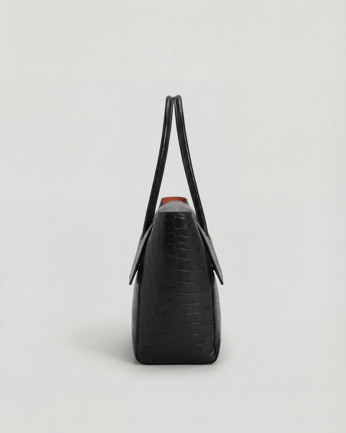 Elegant black crocodile leather handbag by Lumina Wear, featuring an adjustable strap and sophisticated design.