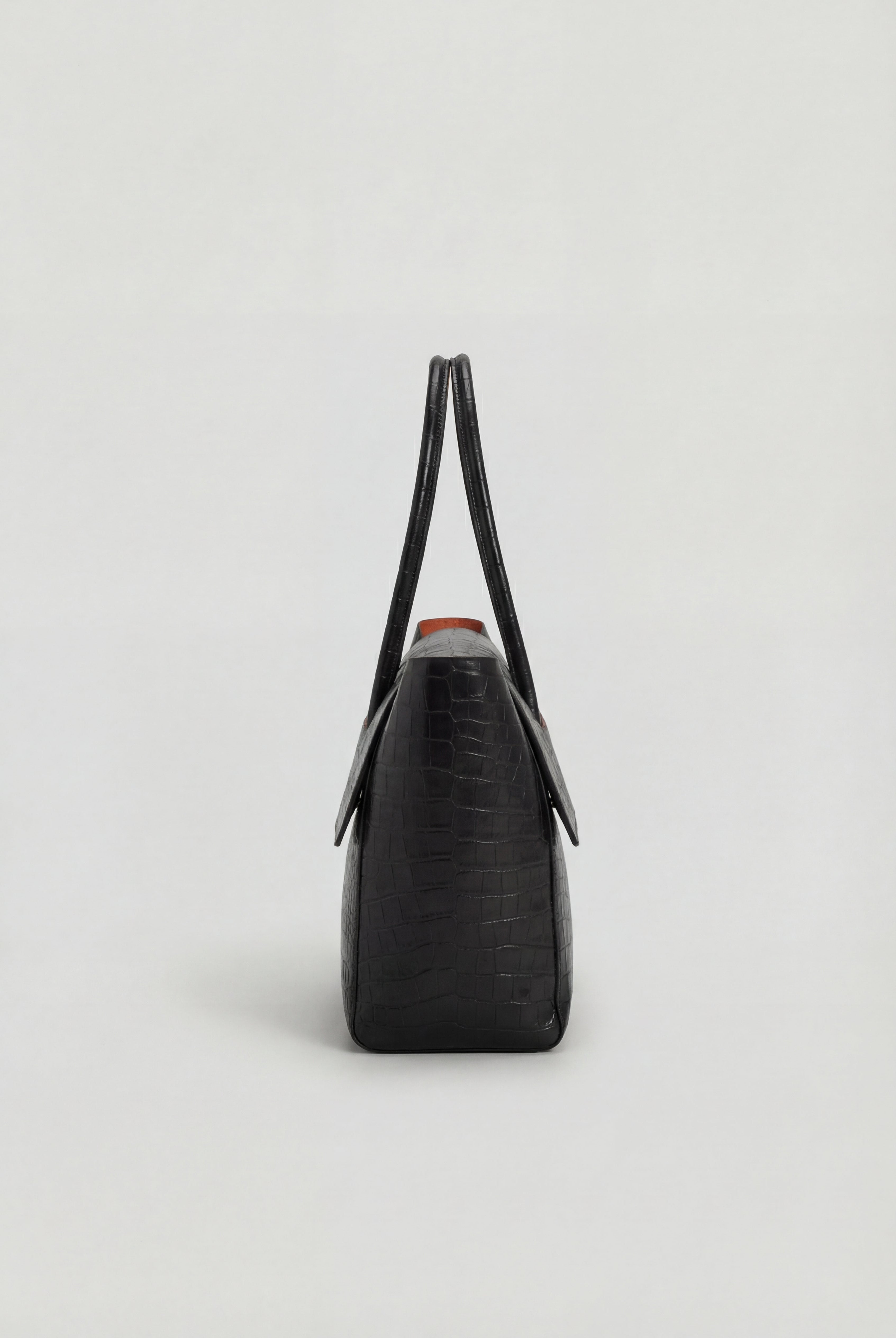 Elegant black crocodile handbag with adjustable strap by Lumina Wear, featuring a sophisticated design and textured finish.