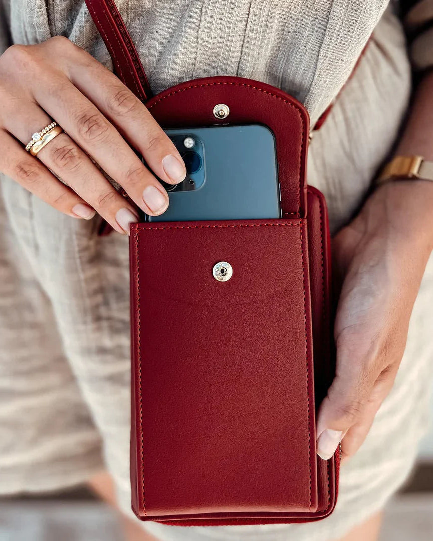 Elegant black leather clutch bag by Lumina Wear with versatile strap, showcasing sleek design and compact form.