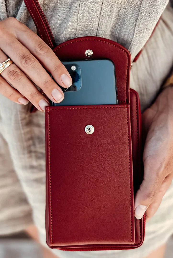 Elegant black leather clutch bag with versatile strap from Lumina Wear, featuring a sleek design and compact hand-held style.