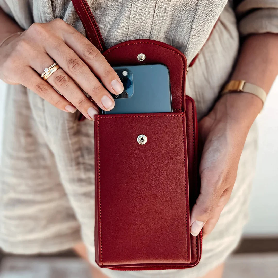 Elegant black leather clutch bag with versatile strap from Lumina Wear, featuring a sleek design and compact hand-held style.