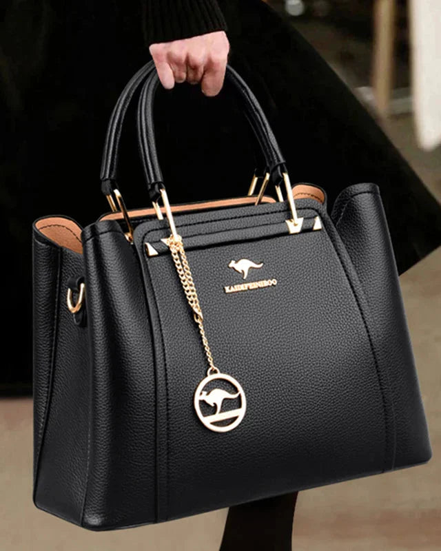 Elegant black leather handbag with gold accents from Lumina Wear, featuring a structured design and stylish details.