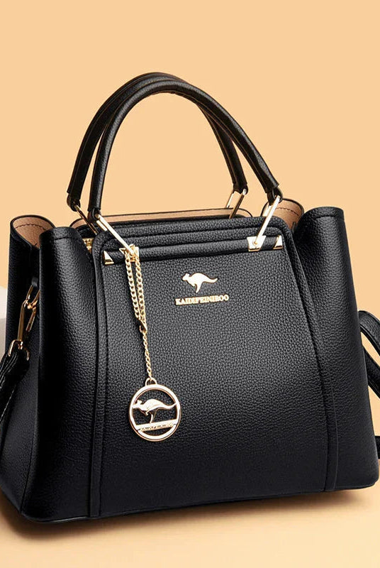 Elegant black leather handbag with gold accents from Lumina Wear, featuring a structured design and top handle.