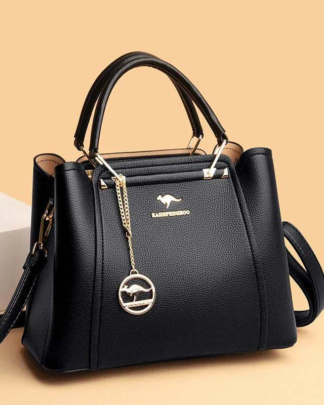 Elegant black leather handbag with gold accents from Lumina Wear, featuring a sleek design and structured shape.