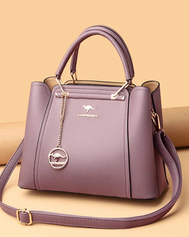 Elegant black leather handbag with gold accents from Lumina Wear, featuring a structured design and stylish handles.
