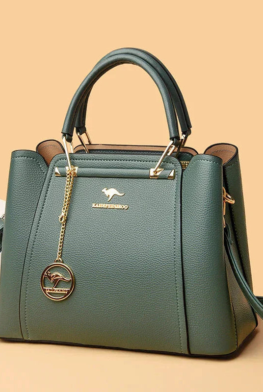 Elegant black leather handbag with gold accents from Lumina Wear's Isabella collection, featuring a structured design and polished finish.