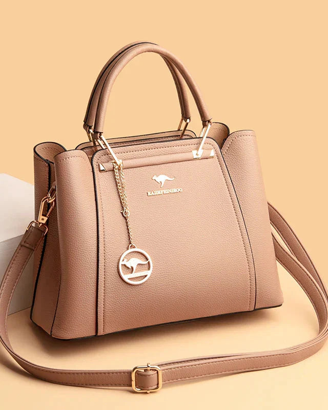 Elegant black leather handbag with gold accents from Lumina Wear, featuring a structured design and top handle.