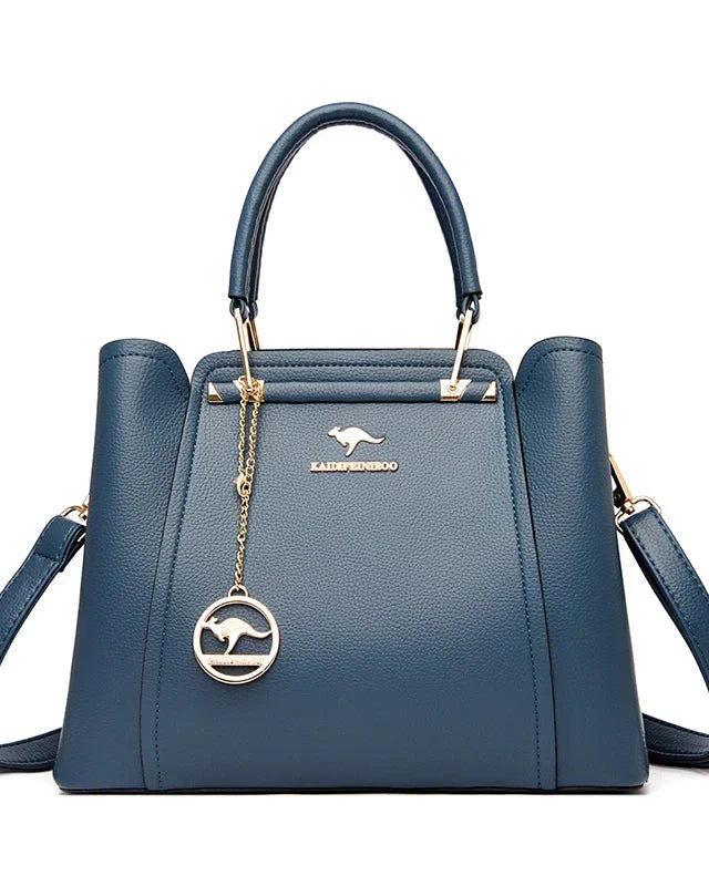 Elegant black leather Lumina Wear Isabella handbag with gold accents, featuring a sleek design and structured shape.