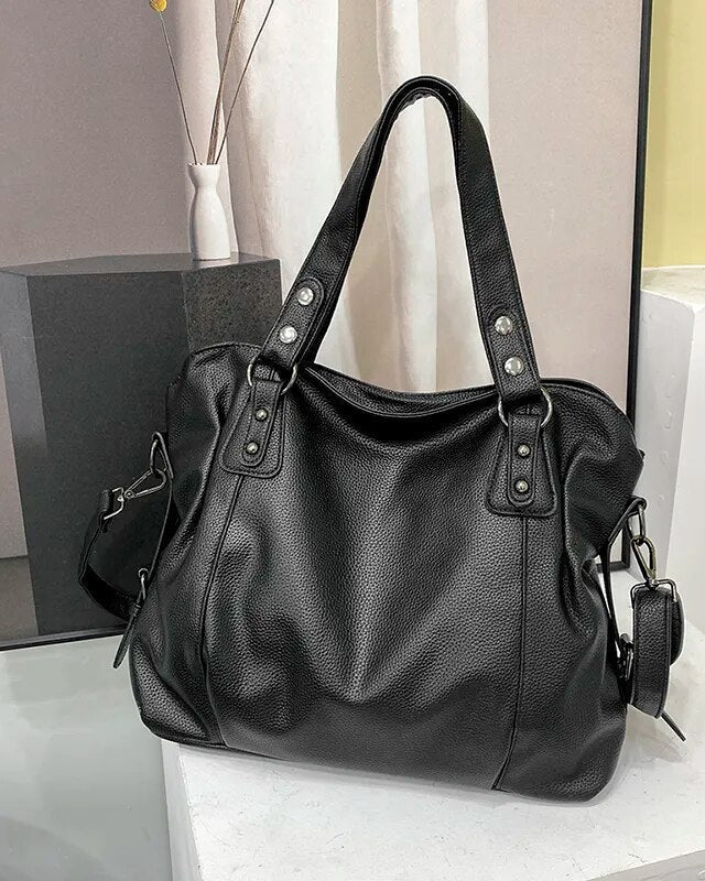 Elegant black synthetic leather tote bag by Lumina Wear featuring structured design and spacious interior.