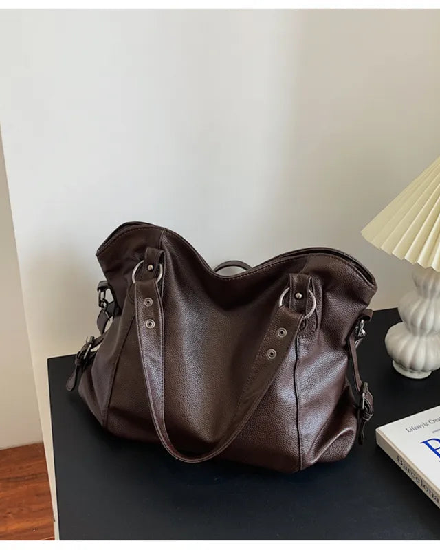 Elegant black synthetic leather tote bag by Lumina Wear featuring a spacious design and sturdy handles.