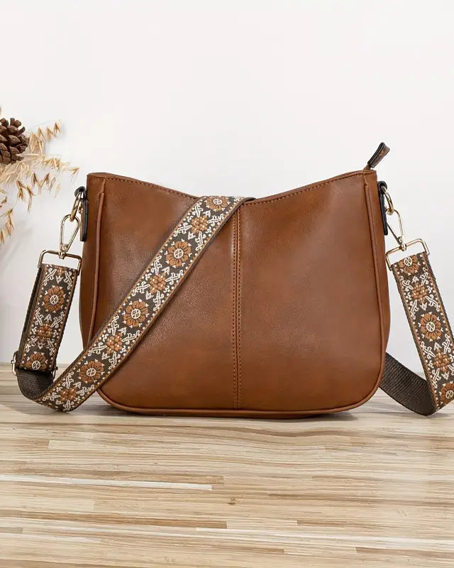 Elegant black vegan leather shoulder bag by Lumina Wear with adjustable strap, featuring a sleek design and top handle.