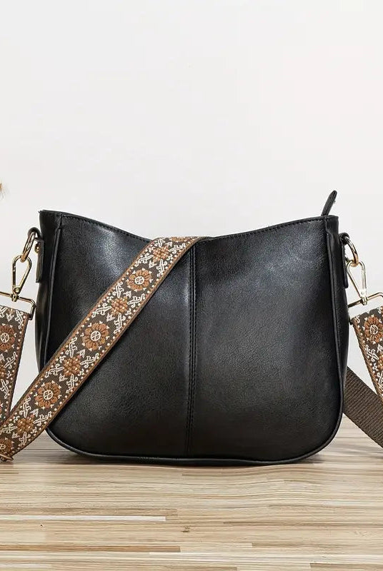 Elegant black vegan leather shoulder bag with adjustable strap from Lumina Wear, featuring a sleek design and spacious interior.