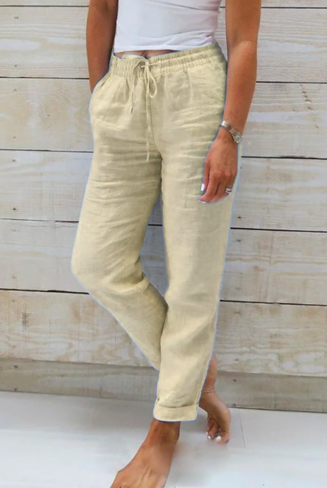 Beige linen trousers from Lumina Wear, lightweight and elegant, with a tailored fit and subtle crease detail.